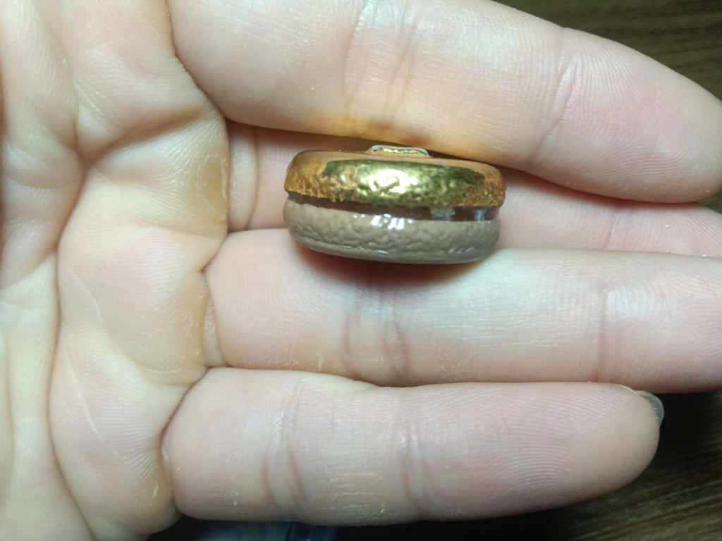 Side view of Ladurée Paris vintage macaron fève showing two-tone macaron shape
