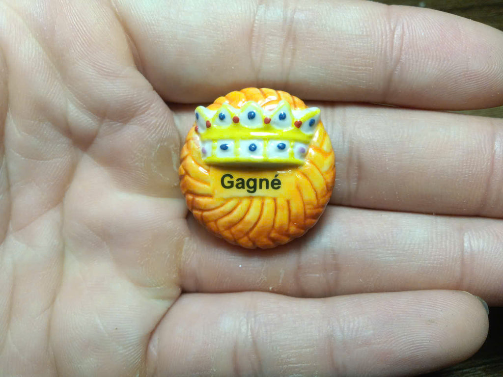 3D jewelled crown fève – deep amber galette with blue and gold crown topped with green gem