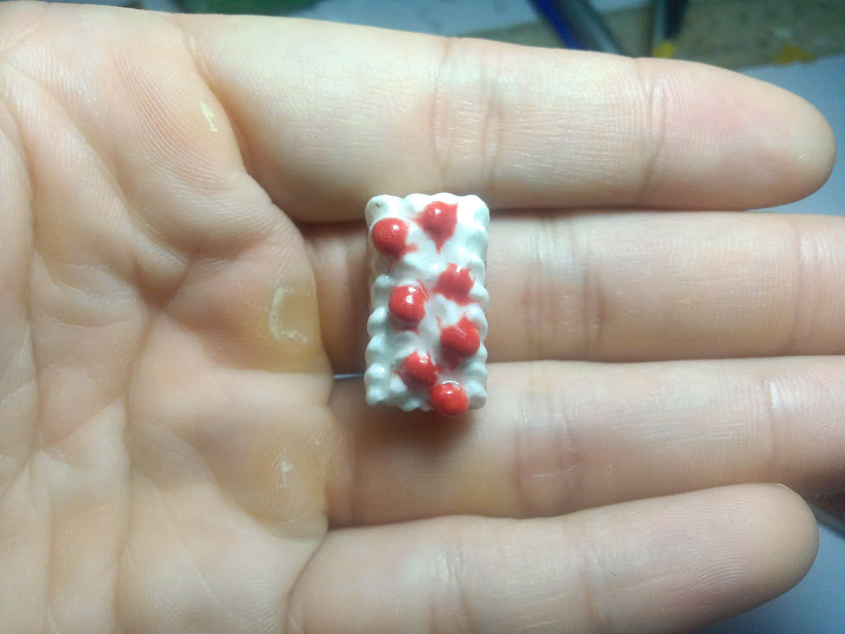 Miniature cake slice fève topped with white cream and red berries