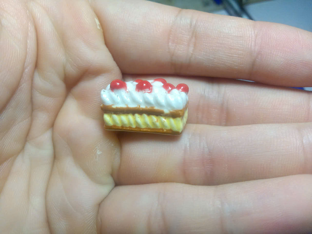Side view of layered French ceramic cake slice fève