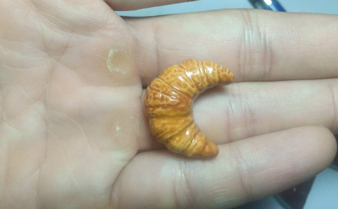 Side view of crescent-shaped miniature croissant fève